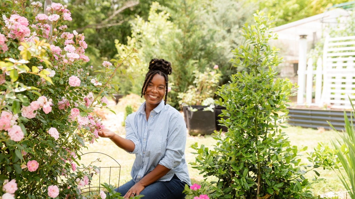 Quilenthia sitting near a obelisk with pink roses