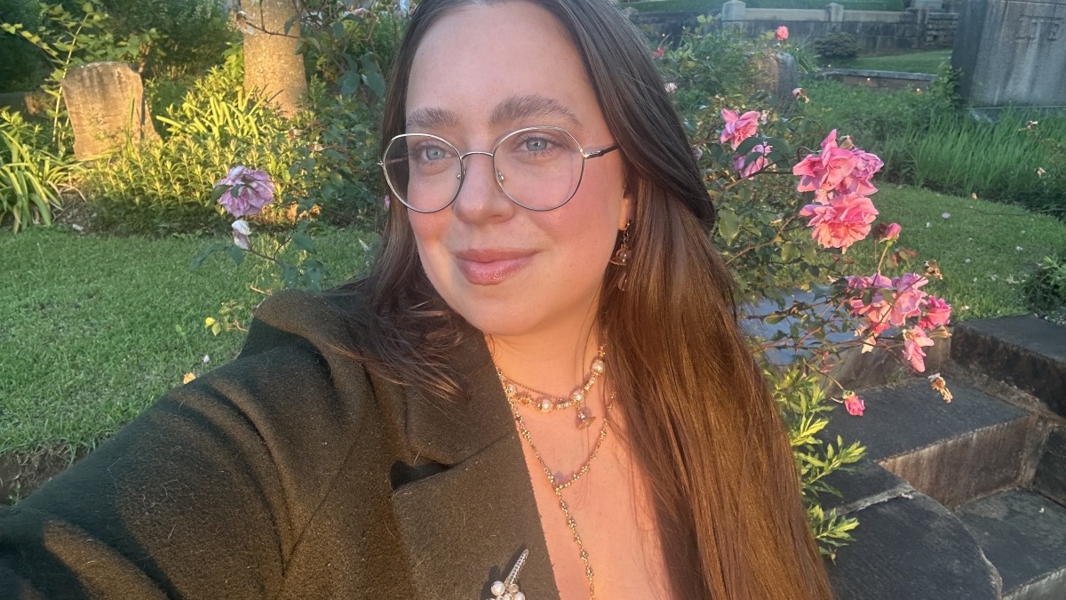 Selfie of a girl smiling with roses in the back